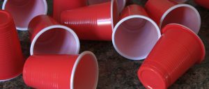 an arrangement of red plastic cups strewn on a countertop.